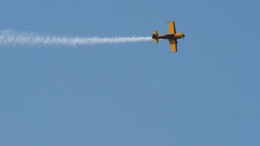 Yellow sports plane fly high in the sky performing spectacular stunts