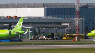 NOVOSIBIRSK, RUSSIAN FEDERATION - JUNY 12, 2022: Airplane of S7 Airlines taxiing to the terminal at airport Tolmachevo, Novosibirsk. View of the airport apron