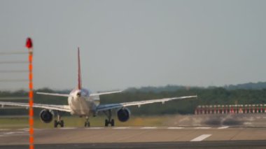 Cinematic shot of civil aircraft takes off, rear view. View of the airfield, airport runway. Passenger airplane departure. Tourism and aviation concept