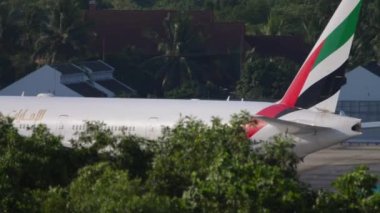 PHUKET, THAILAND - NOVEMBER 30, 2019: Middle shot of Boeing 777 Emirates rides on taxiway of Phuket Airport HKT. Tourism and travel concept