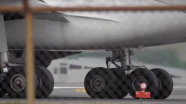 Airplane taxiing. Close-up of the landing gear wheels, tyres on twin-engined passenger aircraft. Aircraft rides along the airport apron