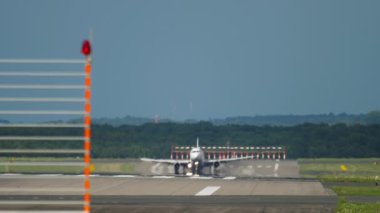 Front view, unrecognizable passenger plane landing on the airport runway in Dusseldorf. Travel and tourism concept