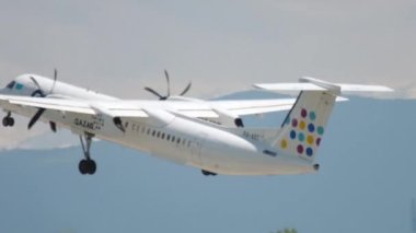ALMATY, KAZAKHSTAN - MAY 4, 2019: Turboprop plane De Havilland Dash-8 of QAZAQ AIR takes off, climbs at Almaty airport, Kazakhstan. Tourism and travel concept