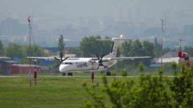 ALMATY, KAZAKHSTAN - MAY 4, 2019: Long shot of turboprop plane QAZAQ AIR departure at Almaty airport, Kazakhstan. Tourism and travel concept