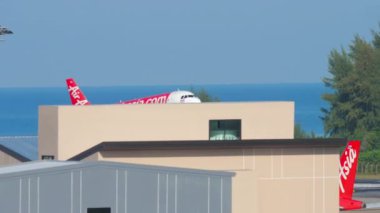 PHUKET, THAILAND - DECEMBER 02, 2018: Passenger low-cost airline Airbus A320 AirAsia landing at Phuket Airport. Aviation traffic. Tourism and travel concept