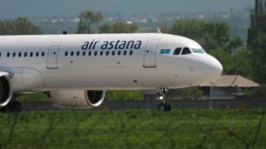 ALMATY, KAZAKHSTAN - MAY 4, 2019: Commercial plane of Air Astana taxiing on the runway at Almaty airport, side view. Mid shot, airplane on the airfield