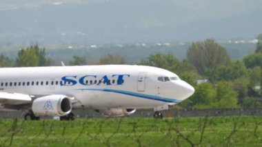ALMATY, KAZAKHSTAN - MAY 4, 2019: Boeing 737 of SCAT Airlines taxiing on the runway at Almaty airport, Kazakhstan. Civil aircraft arrival, side view