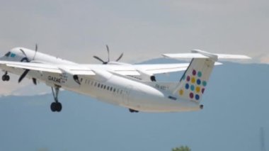 ALMATY, KAZAKHSTAN - MAY 4, 2019: Turboprop plane De Havilland Dash of QAZAQ AIR takeoff at Almaty airport, Kazakhstan. Tourism and travel concept