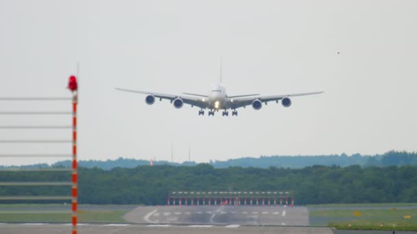 4つのフロントビューエンジンのダブルデッキのワイドボディ航空機着陸 スローモーションに近づいています 巨大な認識できない航空会社の飛行の映像 空港に到着した飛行機のシルエット — ストック動画