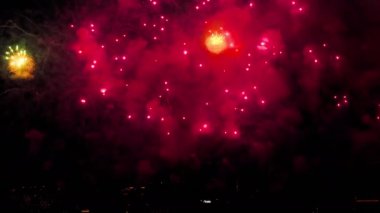 Bright lights of beautiful festive fireworks in the night sky in the city