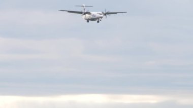 NOVOSIBIRSK, RUSSIAN FEDERATION - JULY 15, 2022: Bottom view of ATR-72 UTair landing. Long shot of a turboprop passenger plane approaching at Tolmachevo airport