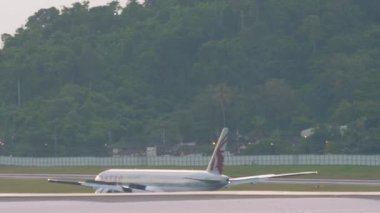 PHUKET, THAILAND - NOVEMBER 27, 2019: Boeing 777 of Qatar Airways braking after landing at Phuket airport. Tourism and travel concept, air flight