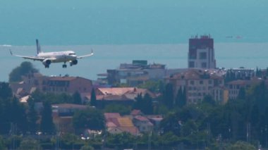 SOCHI, RUSSIA - JULY 28, 2022: Airbus A320neo Ural Airlines landing over the sea at Sochi International Airport. Tourism and travel concept