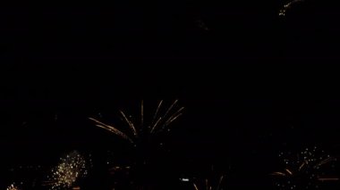 Festive fireworks in the night sky over the city. Holiday concept. Bright lights in honor of the holiday. New Years and Christmas