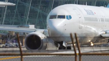 PHUKET, THAILAND - DECEMBER 02, 2018: Cinematic shot of Boeing 737 SilkAir taxiing on the runway. Commercial airliner on the background of a modern airport terminal Tourism and travel concept