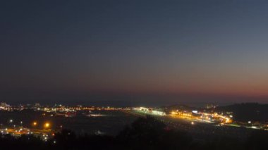 Airport runway at night hour, short time lapse shot. Airplane takeoffs and landings, traffic. Panoramic view of the airport and the city. Tourism and travel concept