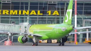 KAZAN, RUSSIA - AUGUST 05, 2022: Airbus A320 of S7 airlines at the Kazan airport terminal. Telescopic bridge, sleeve attached to aircraft. Tourism and travel concept