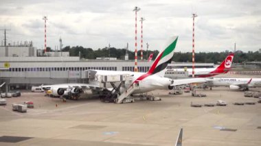 DUSSELDORF, GERMANY - JULY 23, 2017: Airbus A380 Emirates at the terminal of Dusseldorf airport. Boarding passengers using a telescopic bridge. Pre-flight service