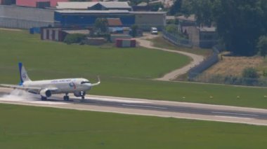 SOCHI, RUSSIA - JULY 28, 2022: Long shot of Airbus A320 Ural Airlines landing and braking at Sochi International Airport. Tourism and travel concept