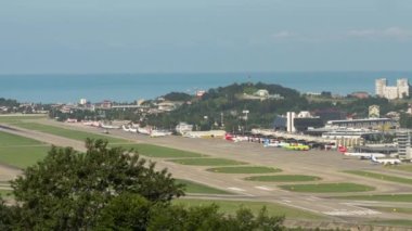 SOCHI, RUSSIA - JULY 29, 2022: Panoramic view of the airfield at Sochi airport. Runway and terminal. Timelapse, takeoffs and landings of aircraft