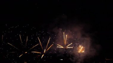 Gece gökyüzünde renkli havai fişekler patlıyor. Kutlamalar ve olaylar parlak renklerle