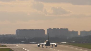 Commercial jet plane speed up before takeoff, rear view. Commercial aircraft flying away. Tourism and travel concept