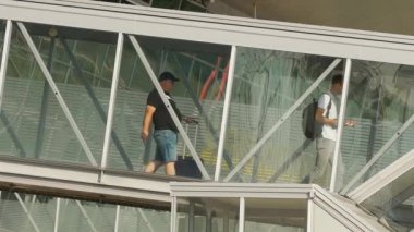 KAZAN, RUSSIA - AUGUST 05, 2022: People go to board the plane through a glass telescopic gangway. Tourism and travel concept