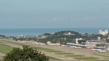 SOCHI, RUSSIA - JULY 29, 2022: Airfield Sochi International Airport. Timelapse of aviation traffic. Panoramic view of the airport runway and the sea in the background