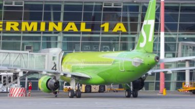 KAZAN, RUSSIA - AUGUST 05, 2022: S7 airlines plane at the Kazan airport terminal. Boarding passengers on board through the telescopic bridge