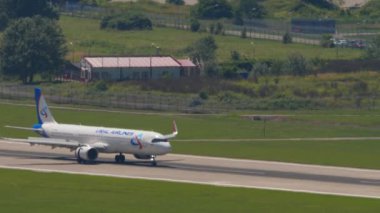SOCHI, RUSSIA - JULY 28, 2022: Airbus A320 of Ural Airlines braking after landing, arrival at Sochi International Airport. Airplane on the runway. Raised flaps. Tourism and travel concept