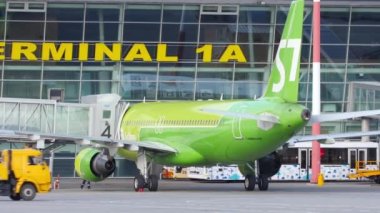 KAZAN, RUSSIA - AUGUST 05, 2022: Passenger plane of S7 airlines at the terminal at Kazan airport. Boarding passengers on board through the airbridge