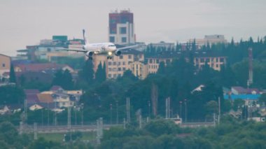 SOCHI, RUSSIA - JULY 30, 2022: Airplane of Ural Airlines landing at Sochi airport. Passenger airliner is approaching, descending to land over the sea and over the city