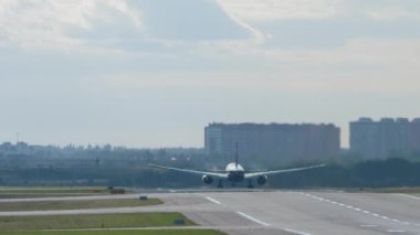 Long shot rear view of a widebody passenger aircraft set to speed and take off. Flight departure early in the morning. Tourism and travel concept