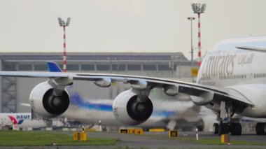 DUSSELDORF, GERMANY - JULY 23, 2017: Huge double deck Airbus A380 of Emirates Airlines taxiing at Dusseldorf airport. Widebody jet passenger aircraft. Cinematic shot of an airplane on the runway