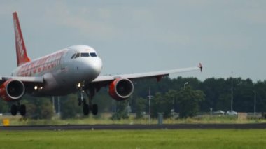 AMSTERDAM, THE NETHERLANDS - JULY 26, 2017: Airbus A320 of EasyJet landing and braking at Schiphol Airport, Amsterdam. Tourism and travel concept
