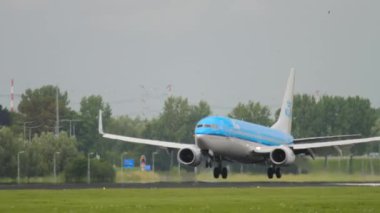 AMSTERDAM, THE NETHERLANDS - JULY 27, 2017: Boeing 737 of KLM landing and braking at Schiphol Airport, Amsterdam. Civil aircraft arrival