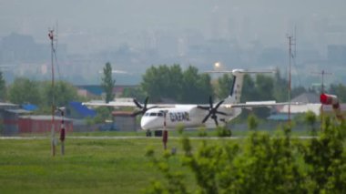 ALMATY, KAZAKHSTAN - MAY 4, 2019: Turboprop passenger aircraft of QAZAQ AIR speed up before takeoff at Almaty airport. Tourism and travel concept.