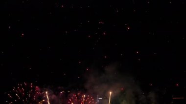 Beautiful festive fireworks in the night sky over the city. Holiday concept. Bright lights in honor of the holiday. New Years and Christmas