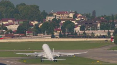 Rear view of a passenger plane taking off and climbing over the sea at Sochi airport. Tourism and travel concept