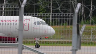 MOSCOW, RUSSIAN FEDERATION - JULY 28, 2021: Commrcial airplane Sukhoi Superjet 100 of Rossiya taxiing at Sheremetyevo Airport SVO. Tourism and travel concept. Airplane on the taxiway