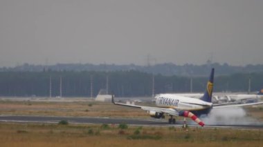 FRANKFURT AM MAIN, GERMANY - JULY 20, 2017: Airplane Boeing 737 Ryanair braking after landing at runway at Fraport, Frankfurt, Germany. Aviation, tourism and travel concept