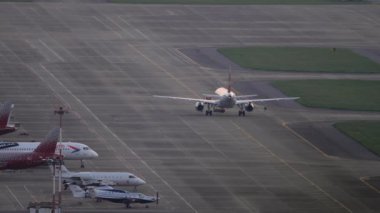 SOCHI, RUSSIA - JULY 27, 2022: Airplane towing on the airfield at sunset or dawn. Tourism and travel concept