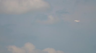 AMSTERDAM, THE NETHERLANDS - JULY 26, 2017: Emirates Airbus A380 fly in the cloudy sky at a long distance. Airliner flew into the cloud. Tourism and travel concept