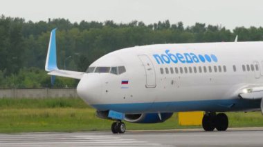 NOVOSIBIRSK, RUSSIAN FEDERATION - JULY 15, 2022: Boeing 737 of Pobeda Air taxiing on the runway at Tolmachevo airport, Novosibirsk. Tourism and travel concept