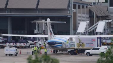 PHUKET, THAILAND - NOVEMBER 28, 2019: Passenger aircraft Bangkok Air docked at the terminal. Loading food on board. Tourism and travel concept