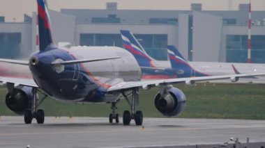 MOSCOW, RUSSIAN FEDERATION - JULY 28, 2021: Commercial aircraft Airbus A320 of Aeroflot Airlines on the taxiway. Airplane taxiing on the runway. Airport building in the background