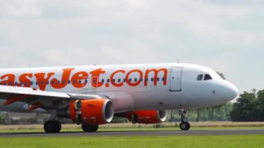 AMSTERDAM, THE NETHERLANDS - JULY 26, 2017: Airbus A319-111, G-EZBB of EasyJet braking after landing at Schiphol Airport, Amsterdam. Tourism and travel concept