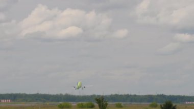 Unrecognizable plane taking off and climbing, long shot rear view. Tourism and travel concept