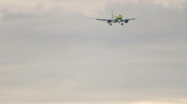 Jet passenger airplane approaching to landing. Slow motion, airliner is flying. Tourism and travel concept