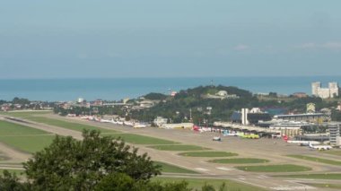 SOCHI, RUSSIA - JULY 29, 2022: View of the airfield of a modern airport on a summer day, timelapse. Aviation traffic, panoramic platform